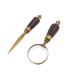 Brass paper knife and magnifying glass on a stand in a leather frame