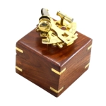 A small brass sextant in a wooden box