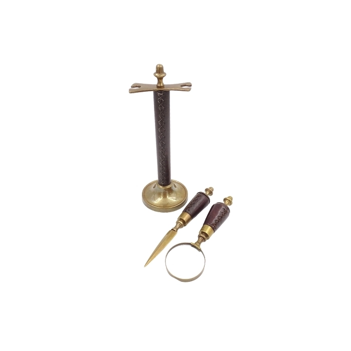 Brass paper knife and magnifying glass on a stand in a leather frame