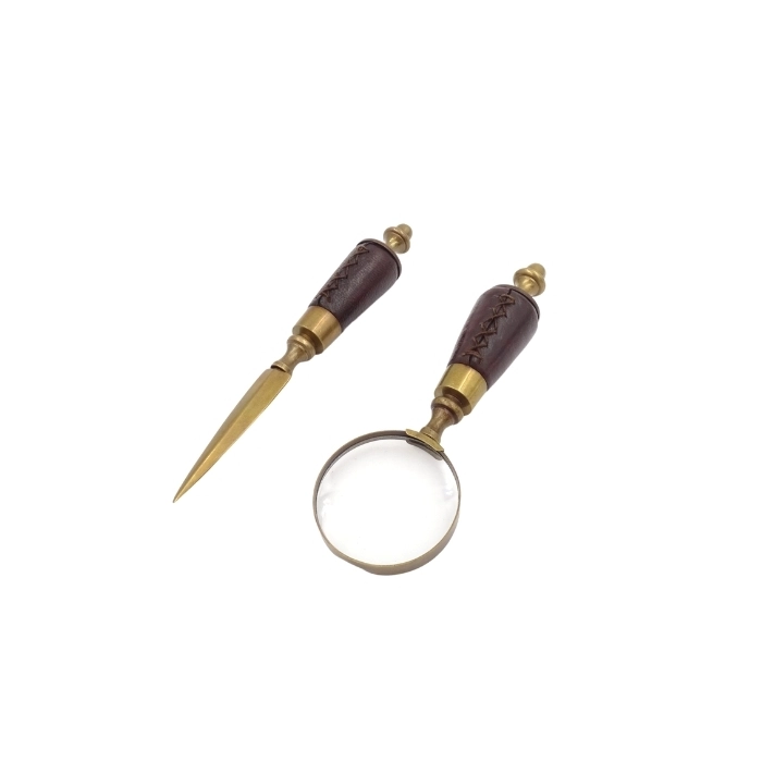 Brass paper knife and magnifying glass on a stand in a leather frame