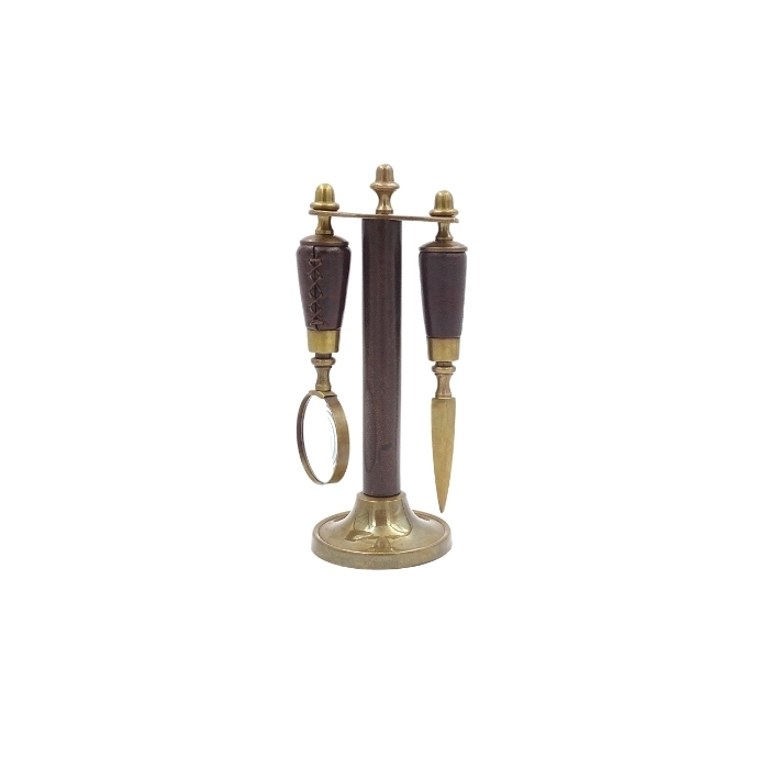 Brass paper knife and magnifying glass on a stand in a leather frame